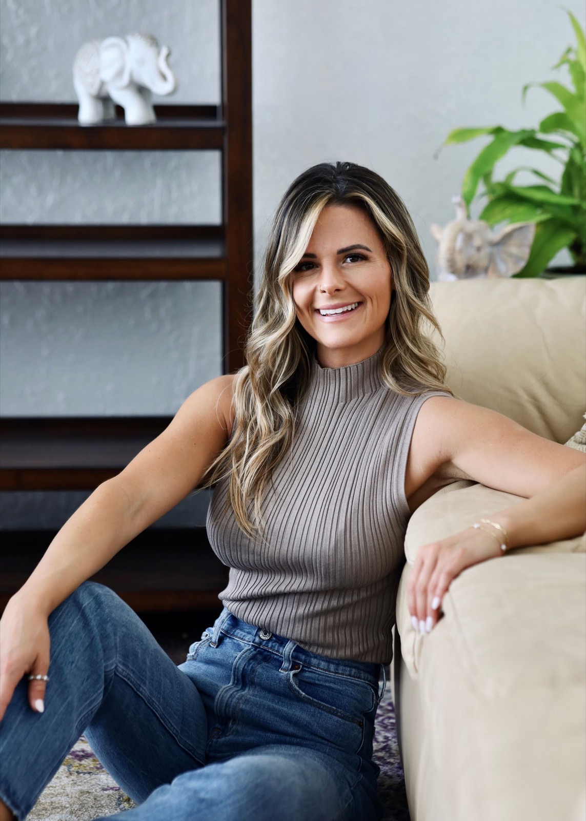 Tayler Lee seated on a sofa, smiling toward the camera